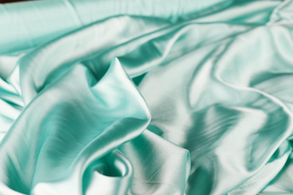 a close up of a bed with a white and blue comforter