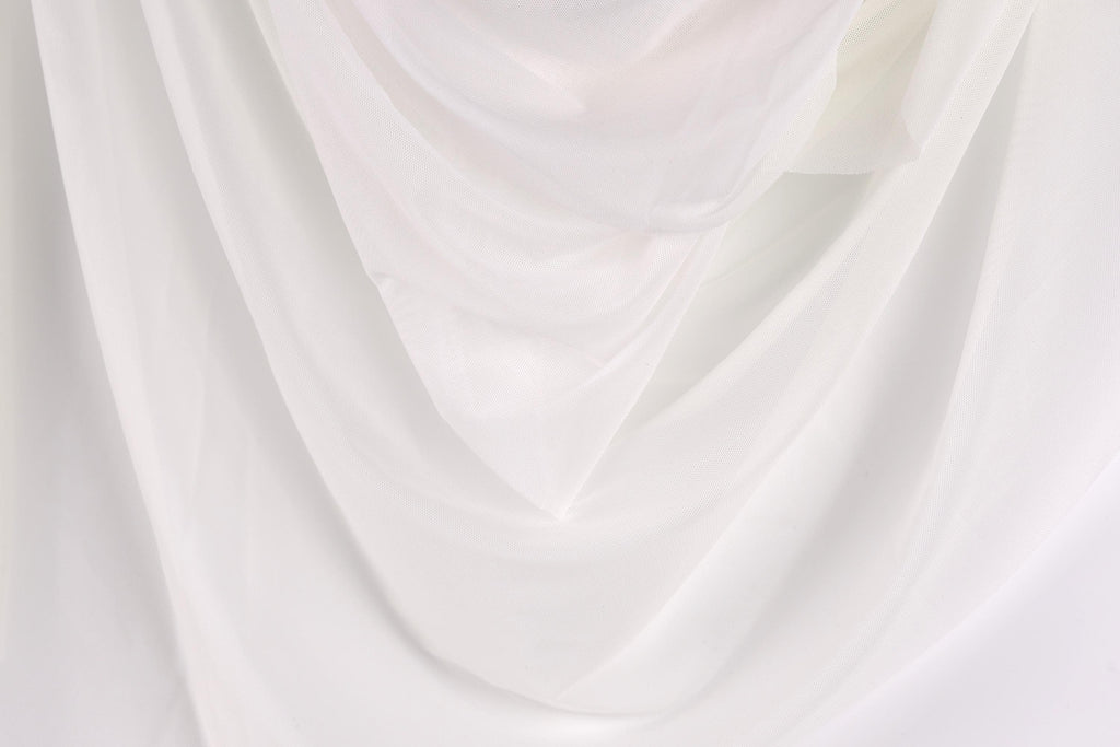The image is a close-up of a white fabric, possibly a sheer or sheer-like material, with a soft, flowing texture.