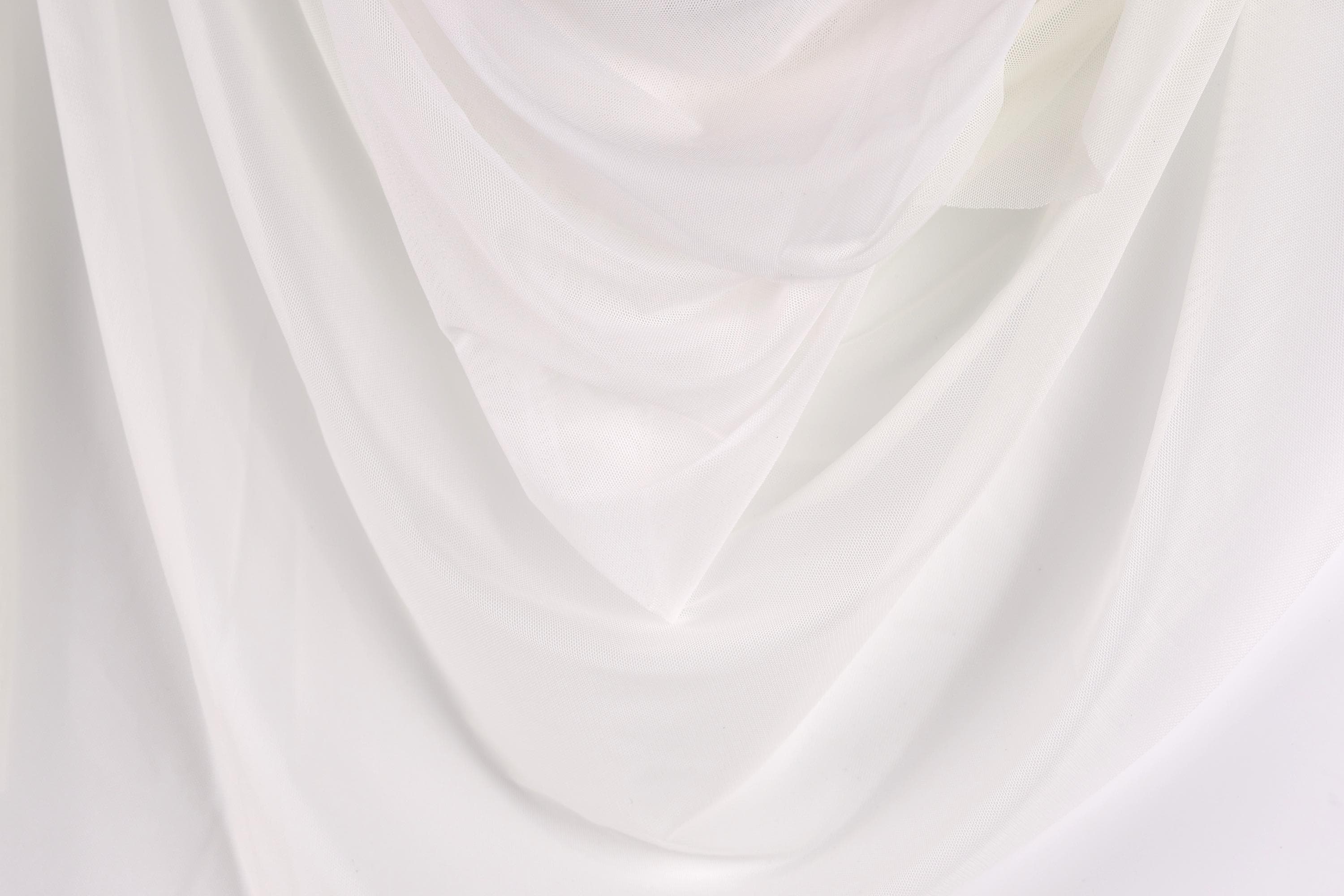The image is a close-up of a white fabric, possibly a sheer or sheer-like material, with a soft, flowing texture.