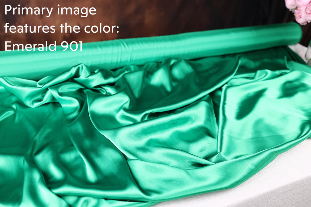 a roll of green satin fabric, with the text &quot;Primary image features the color: Emerald 901&quot; visible.