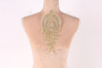 a mannequin with a decorative gold embroidered piece on its back.