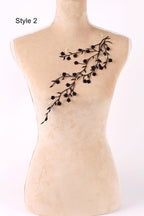 A mannequin with a beige body and a black branch-like design on its chest.