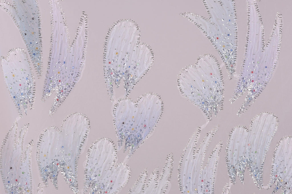 a pattern of white and silver glittering leaves or flowers against a light purple background.