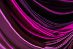 a close-up view of a fabric with a gradient of colors, transitioning from a deep purple to a lighter shade of purple. The fabric appears to be made of satin or a similar smooth, shiny material, and it is folded or draped in a way that creates a sense of depth and texture.