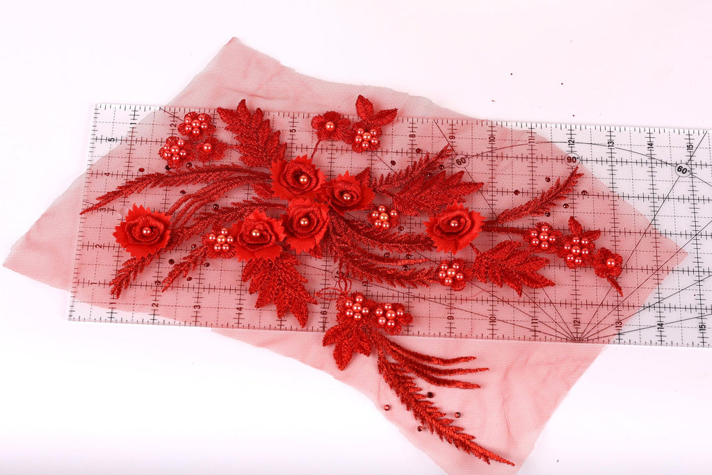 a collection of red flowers and leaves, including roses and ferns, arranged on a transparent surface.