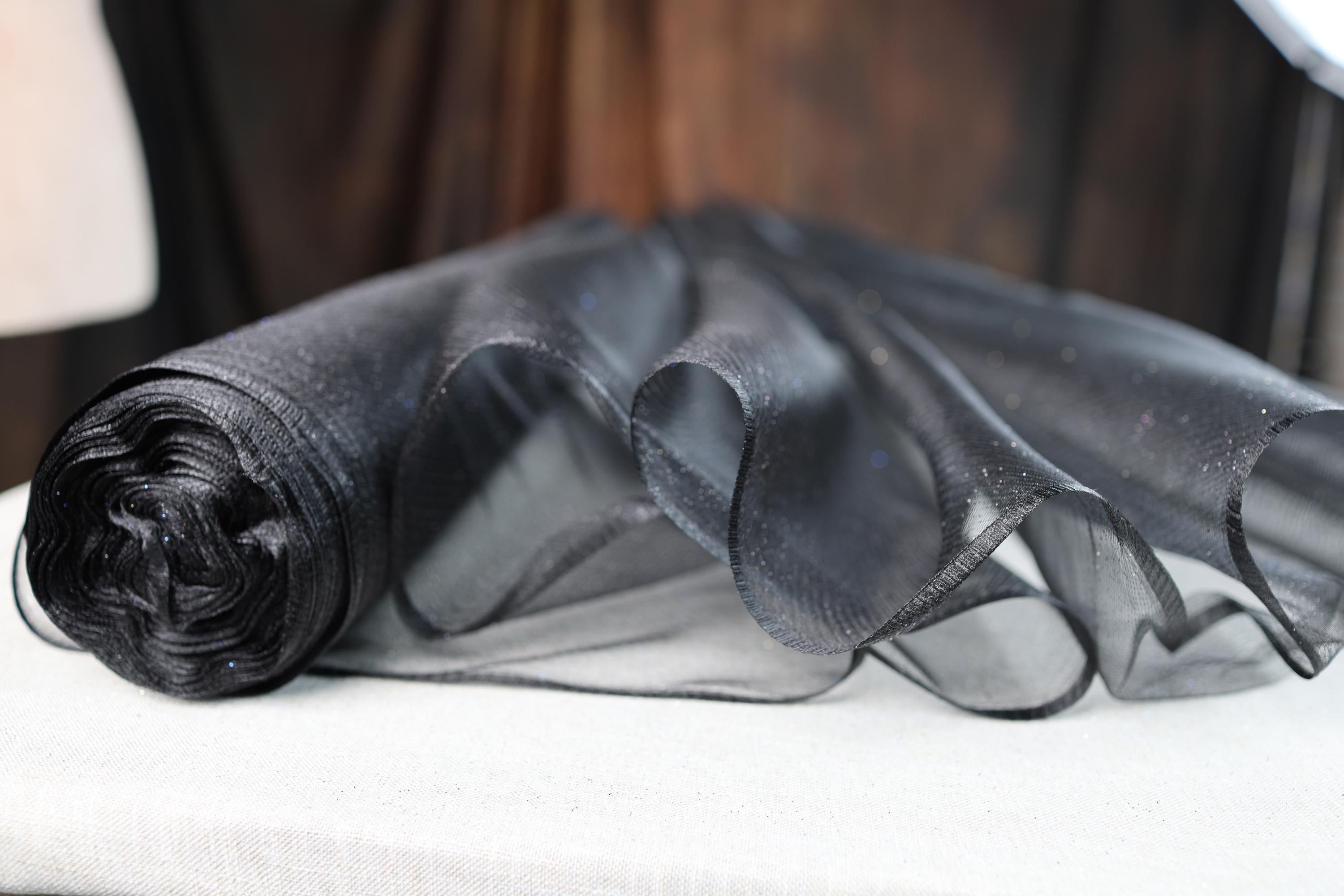 a piece of black sheer fabric sitting on top of a table
