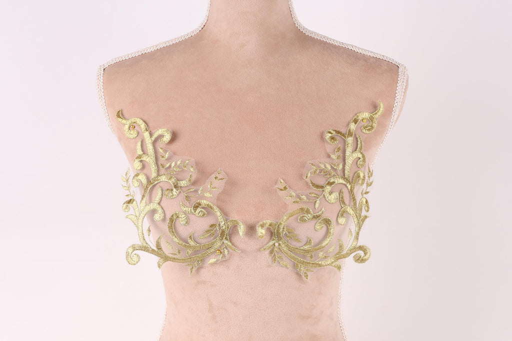 a mannequin torso with gold embroidered leaf-like patterns on the bust area.
