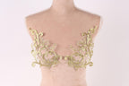 a mannequin torso with gold embroidered leaf-like patterns on the bust area.