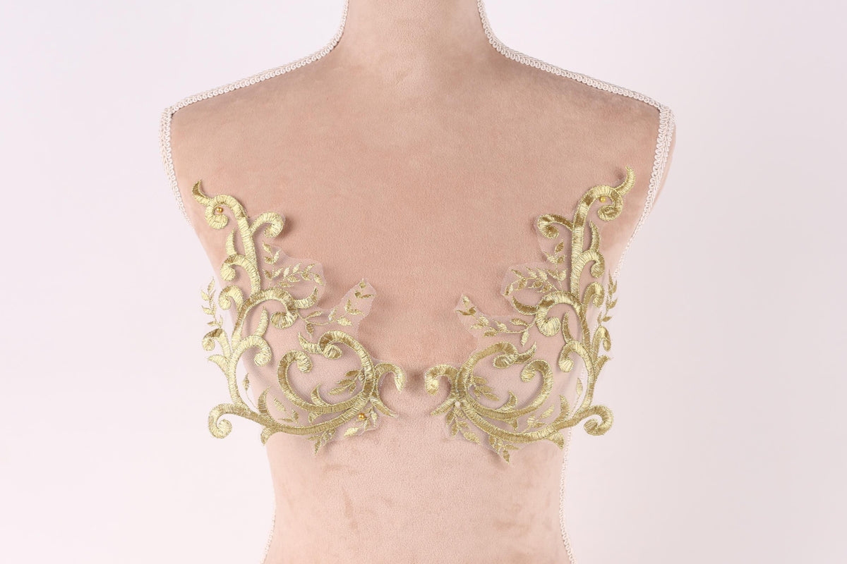 a mannequin torso with gold embroidered leaf-like patterns on the bust area.