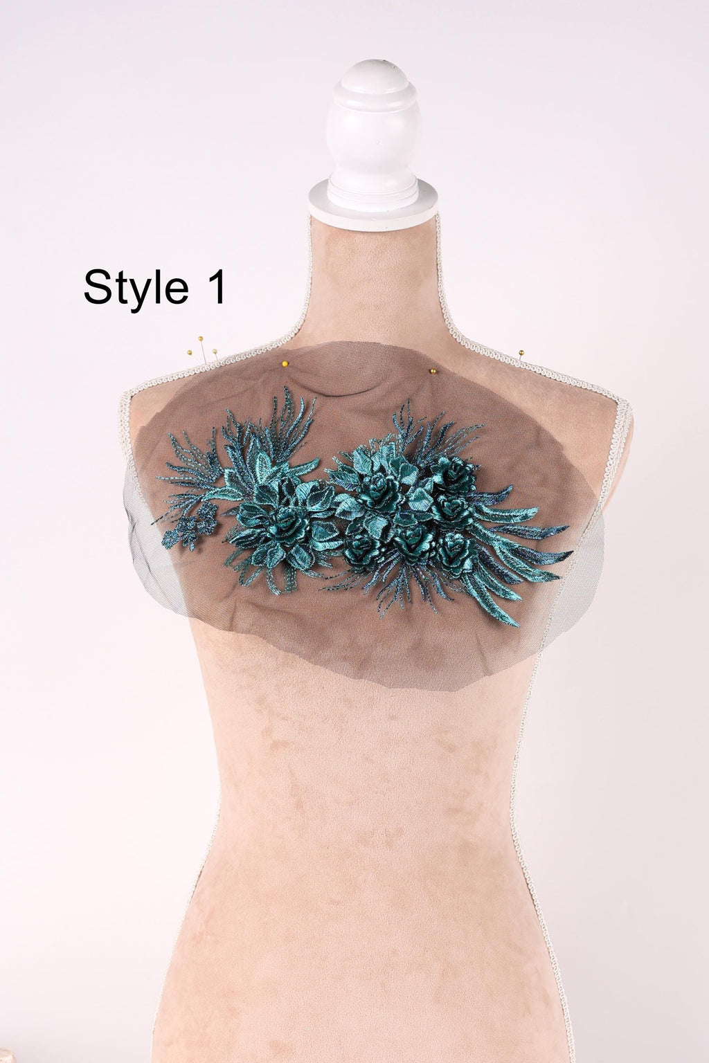 A mannequin with a decorative floral embroidered on its bust area, displayed against a plain background.