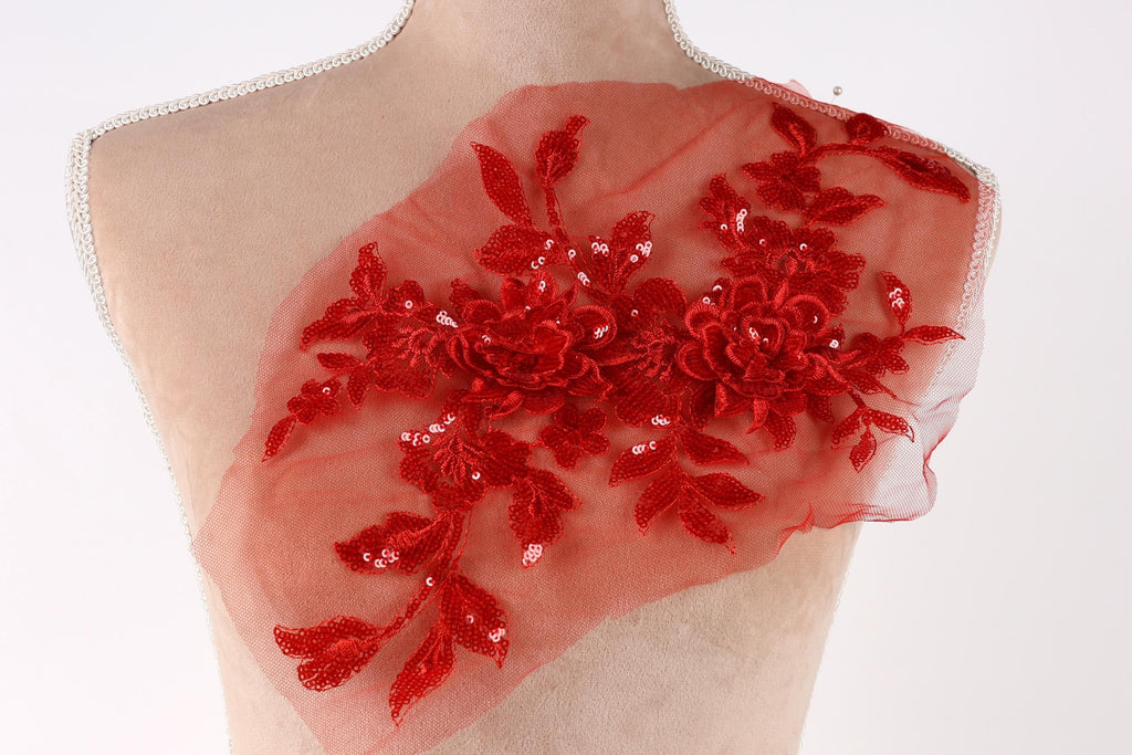 A mannequin torso with a red floral embroidered patch on it.