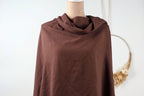 A mannequin wearing a brown, knitted garment with a scarf draped over it, displayed against a white background.
