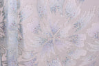 a close-up view of a fabric with a floral pattern, adorned with small, colorful beads or sequins that add a decorative touch.