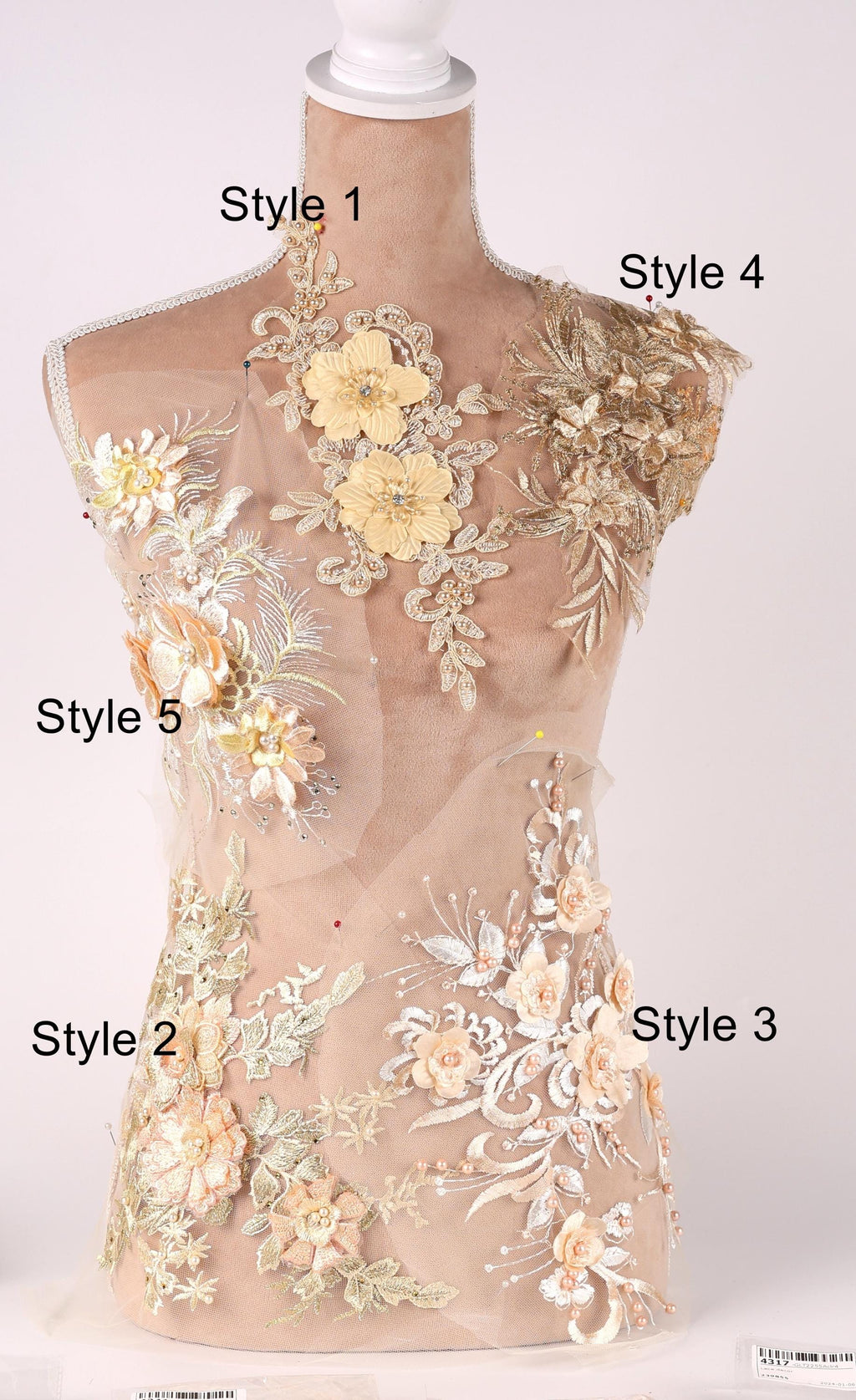 A mannequin with various floral and lace designs on its body, including different styles of dresses or garments.