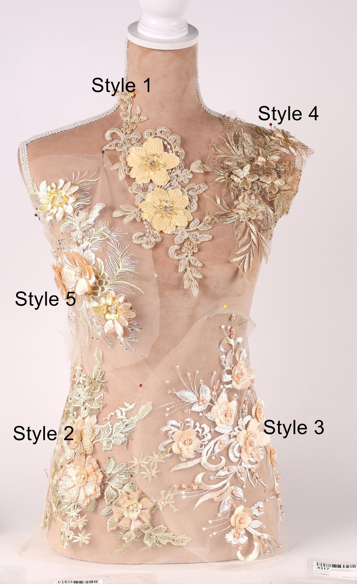 A mannequin with various floral and lace designs on its body, including different styles of dresses or garments.