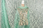 a mannequin wearing a sequin dress with a mint green color. The dress has a shimmering, sequined pattern that creates a visually striking appearance.