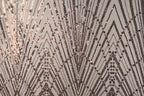 a close-up view of a textured surface with a repeating pattern of diagonal lines and small dots in shades of brown and black.