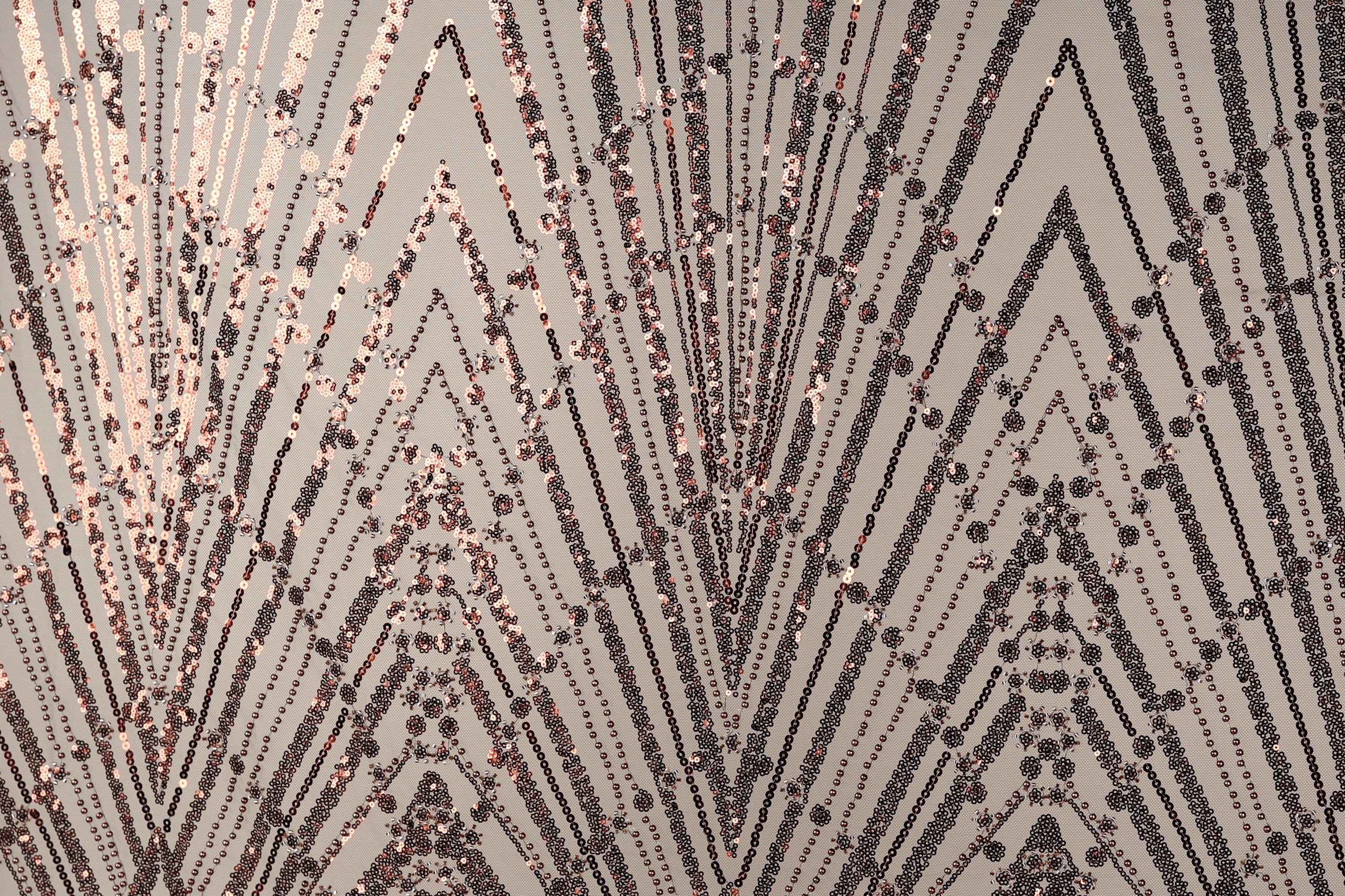 a close-up view of a textured surface with a repeating pattern of diagonal lines and small dots in shades of brown and black.
