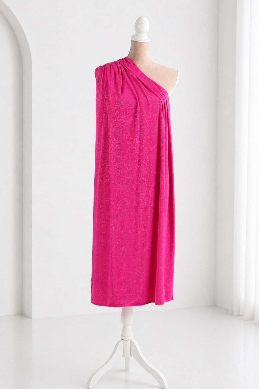 A mannequin wearing a bright pink one-shoulder dress stands on a white stand against a white background.