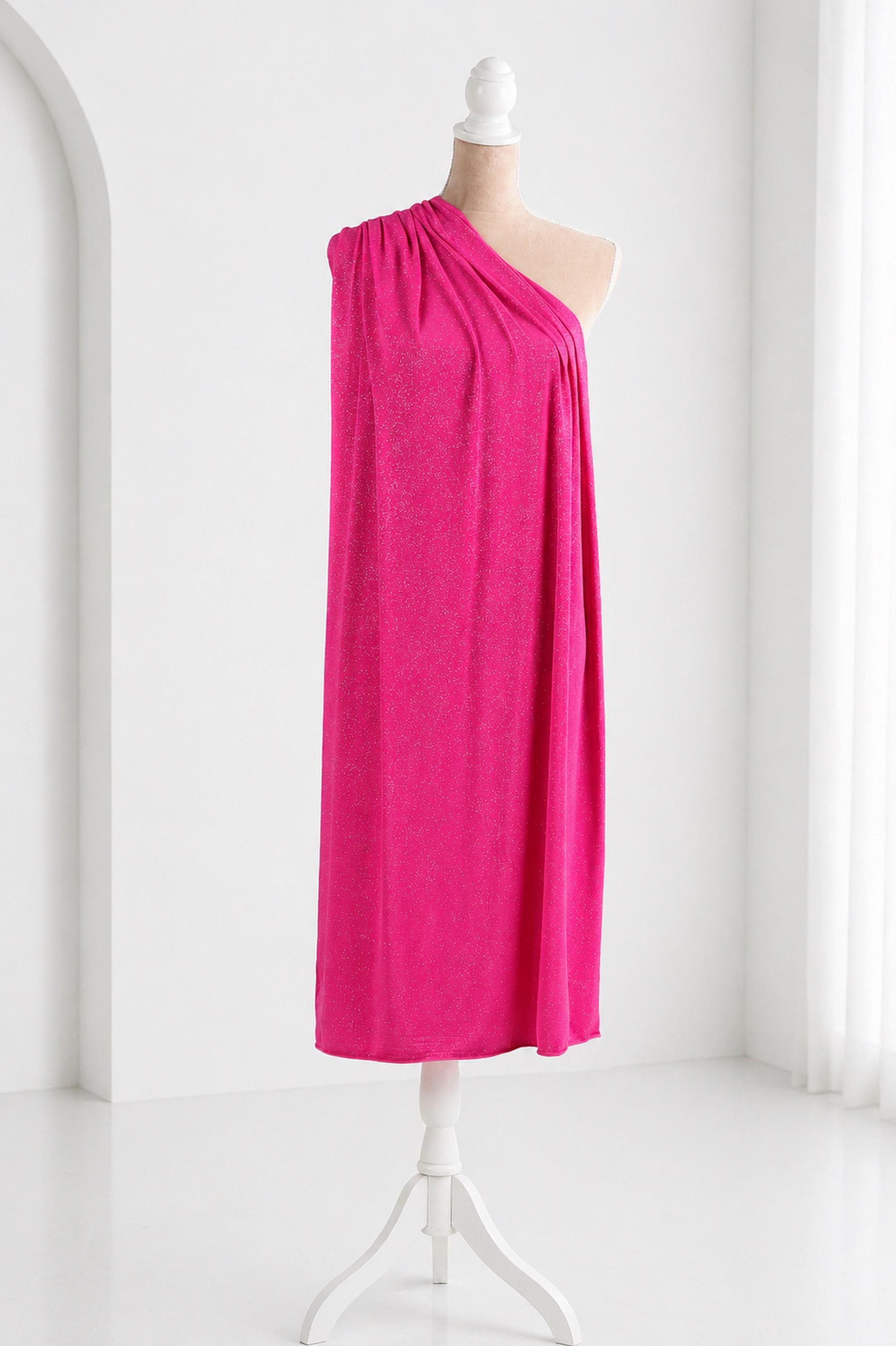 A mannequin wearing a bright pink one-shoulder dress stands on a white stand against a white background.