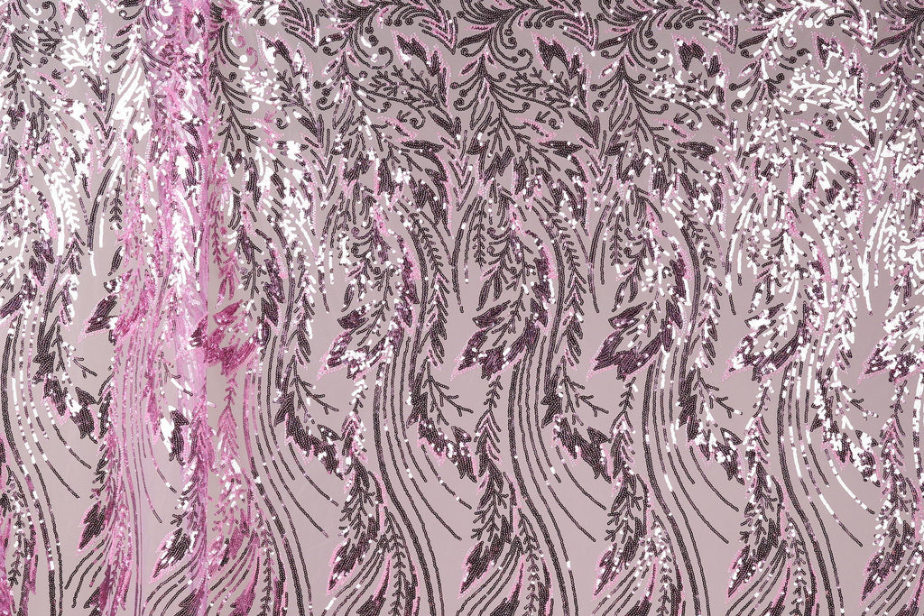a close-up view of a fabric with a repeating pattern of pink and black sequin designs. The pattern consists of various shapes and sizes of sequins arranged in a diagonal line across the fabric, creating a visually striking and intricate design.
