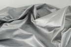 a close-up view of a crumpled, shiny, and textured fabric, possibly silver or gray in color.