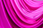 The image is a close-up of a fabric with a soft, shiny texture in shades of pink and purple. The fabric appears to be made of satin or a similar smooth material, and it is folded or draped in a way that creates a sense of movement and depth. The colors are vibrant and the fabric looks luxurious and comfortable.