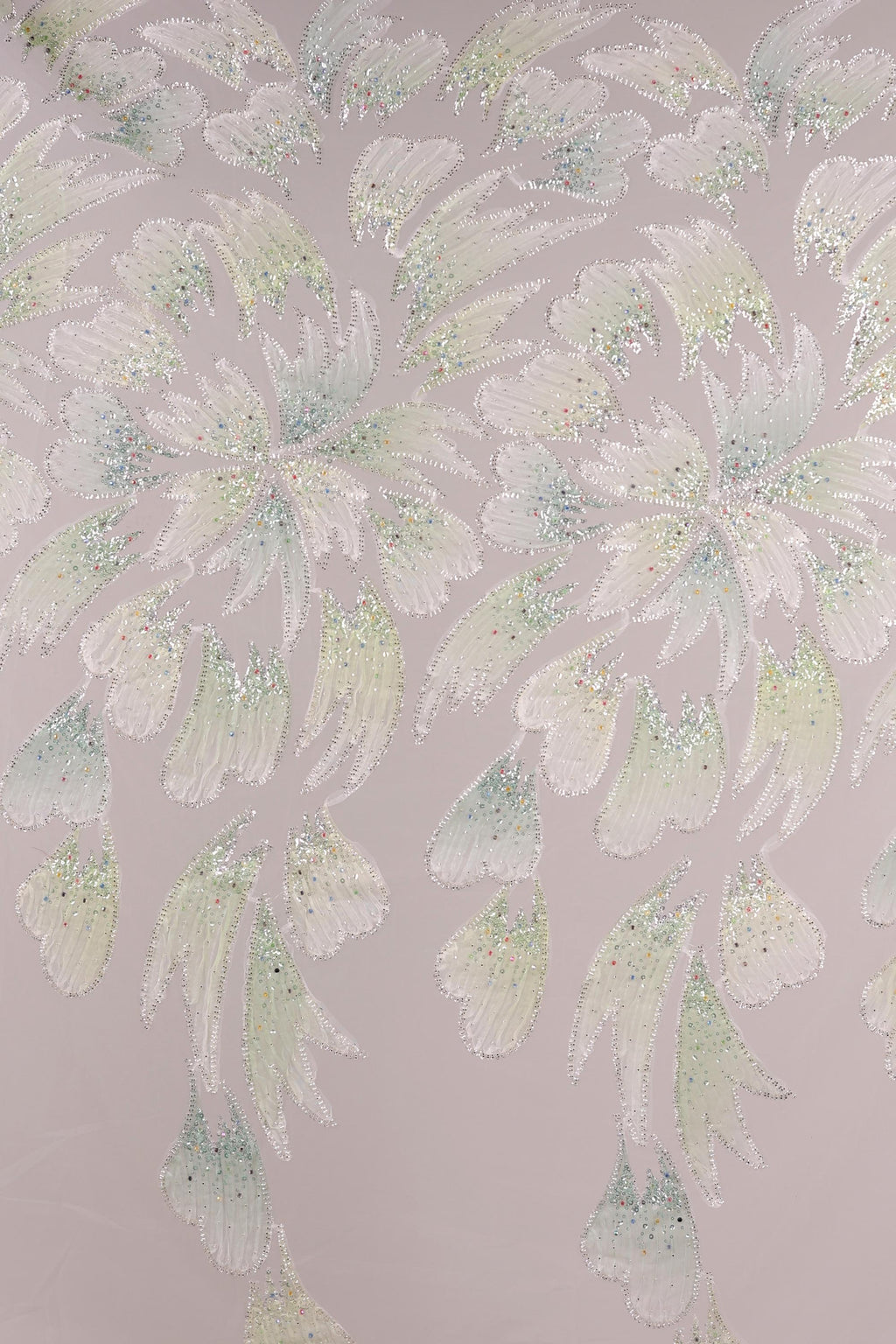 a repeating pattern of white and green floral designs on a light pink background.