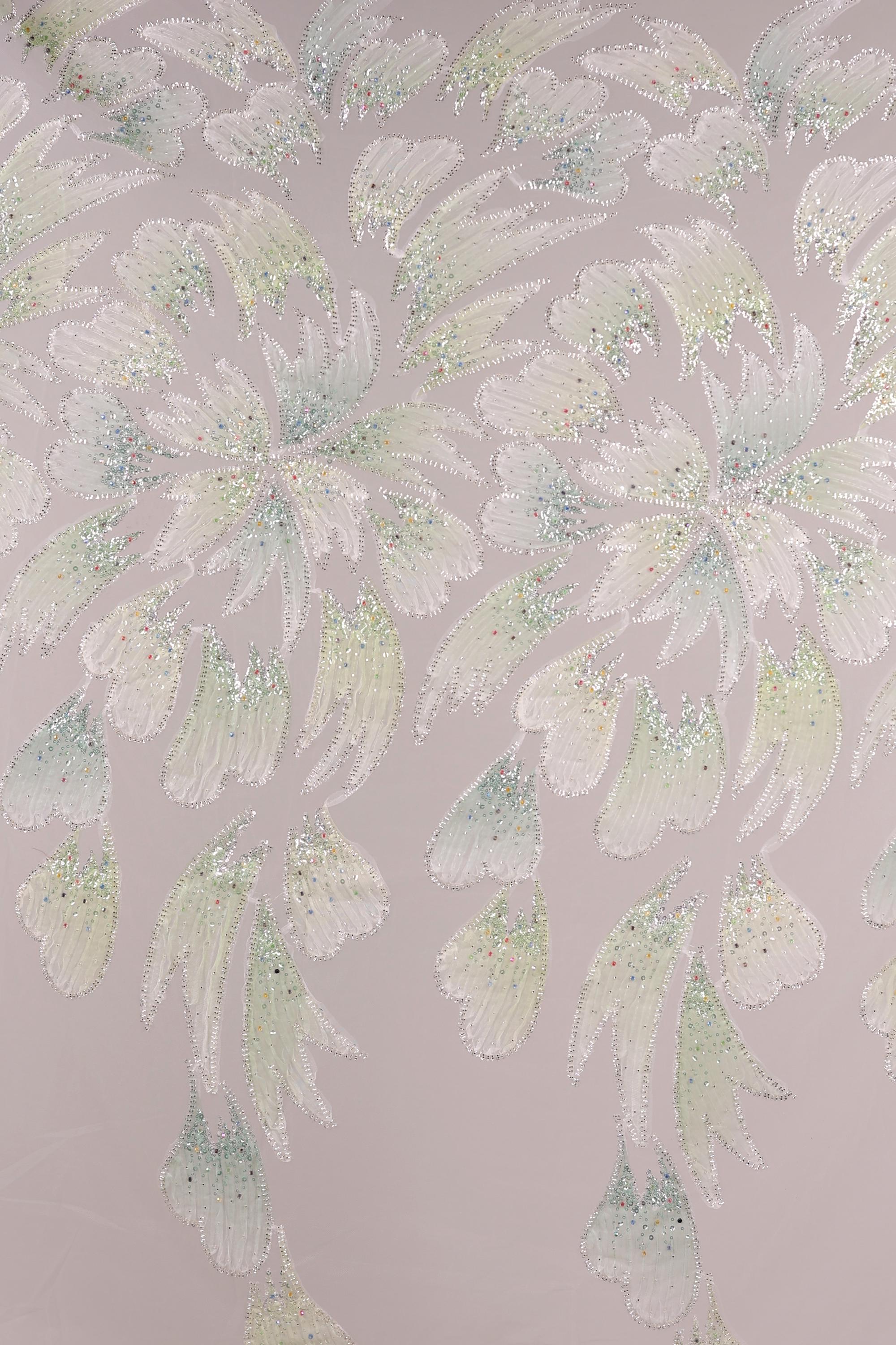 a repeating pattern of white and green floral designs on a light pink background.