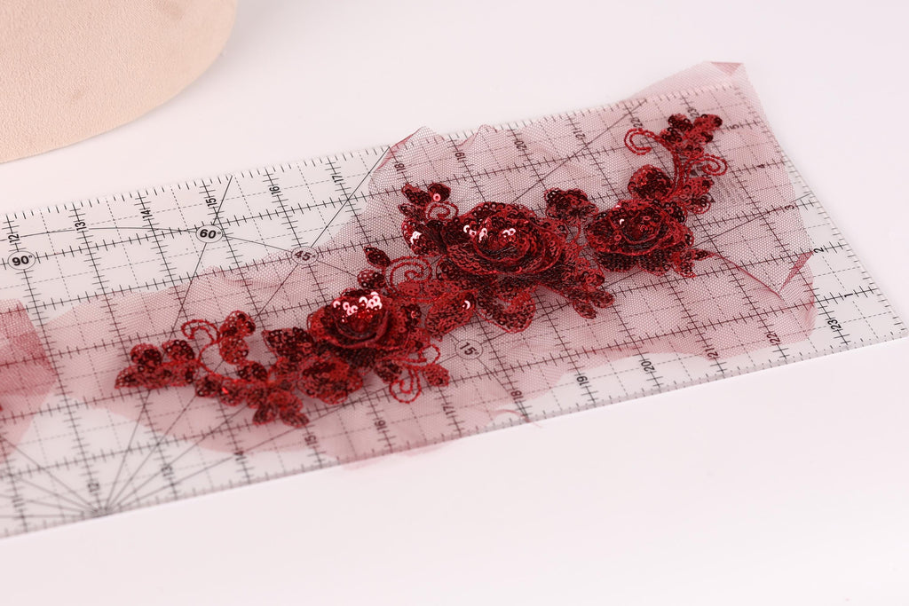 a clear ruler with red sequin flowers printed on it.