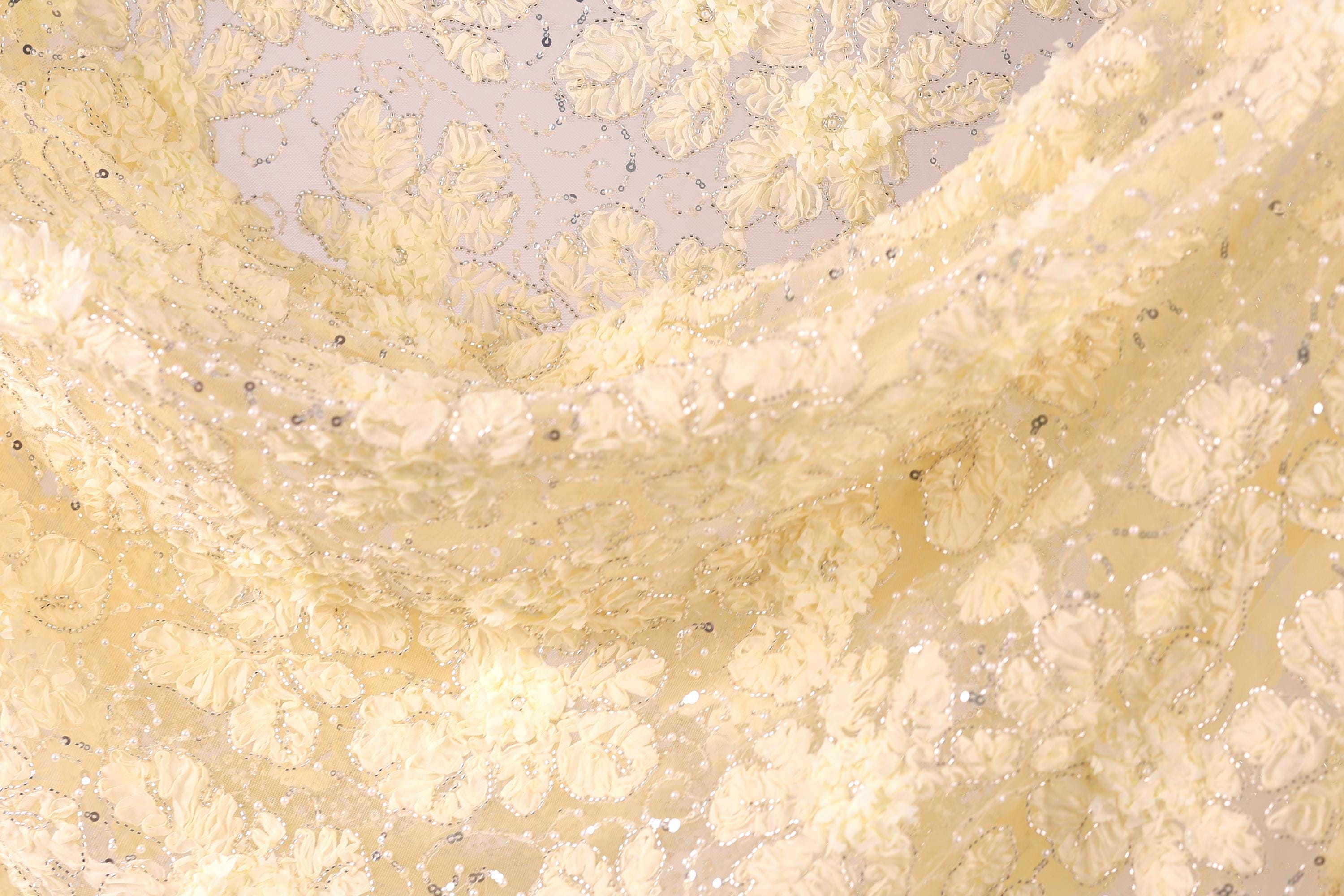 The image is a close-up of a fabric with a floral pattern, featuring yellow flowers and a white background.