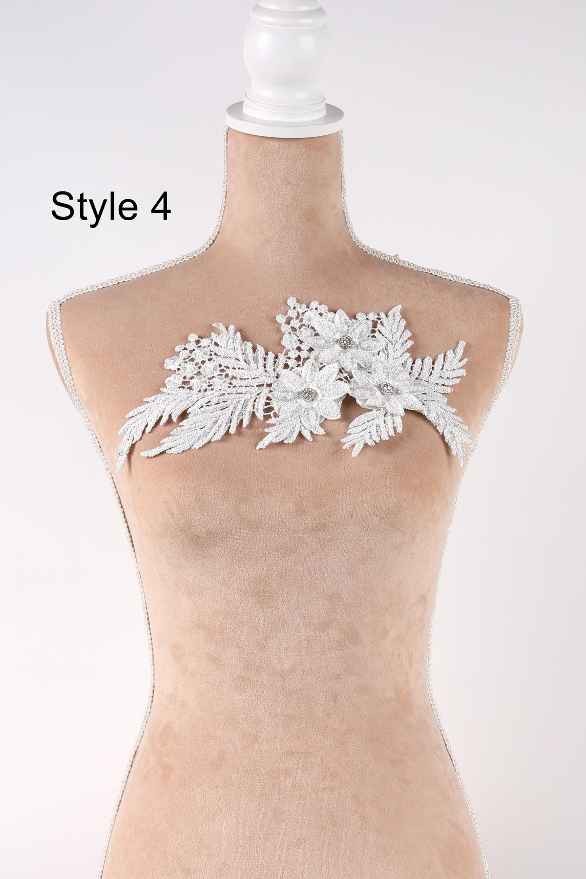 A mannequin with a decorative lace piece on its bust, featuring a floral design.