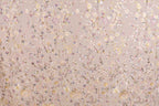 a pattern of pink and white flowers and leaves, with some areas of the flowers appearing to be sequined or embellished.