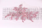 a collection of pink and white floral designs, including flowers and leaves, arranged on a transparent ruler.