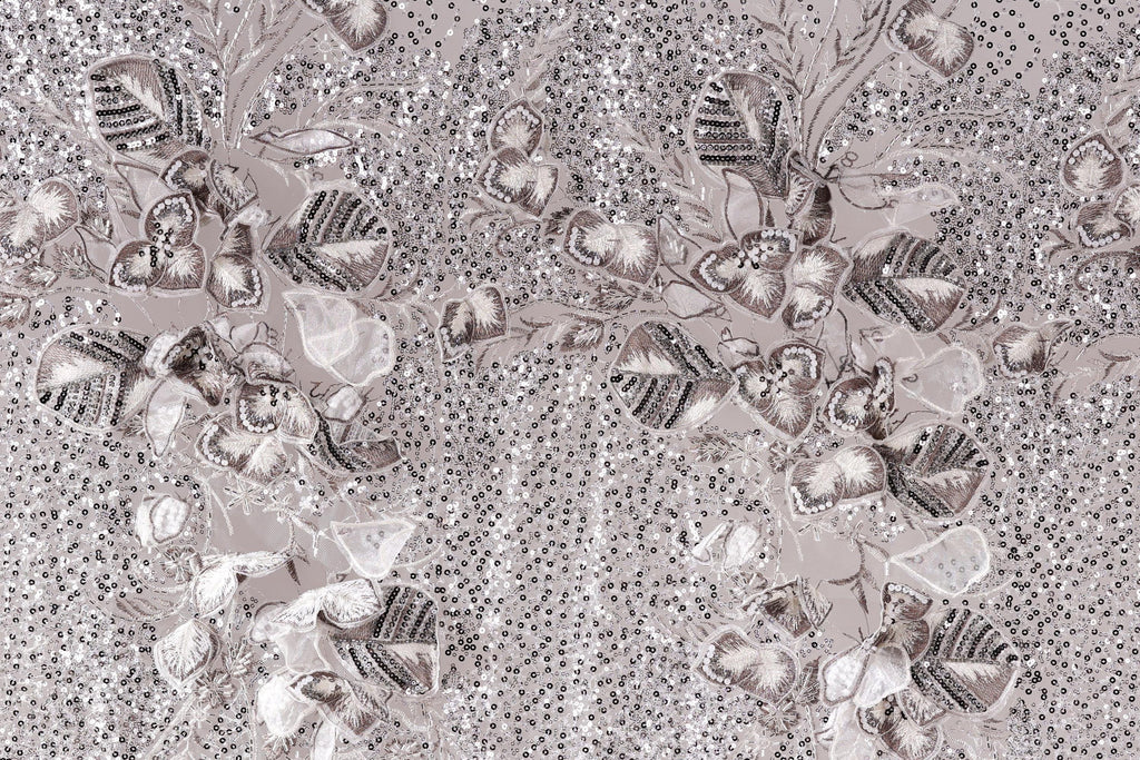 The image is a close-up of a fabric with a floral pattern, featuring a variety of leaves and flowers in shades of gray and white. The pattern is intricate and detailed, with the leaves and flowers arranged in a visually appealing manner. The background of the image is a light gray color, which contrasts with the darker tones of the floral pattern. The overall composition of the image is balanced and harmonious, with the floral pattern taking center stage.