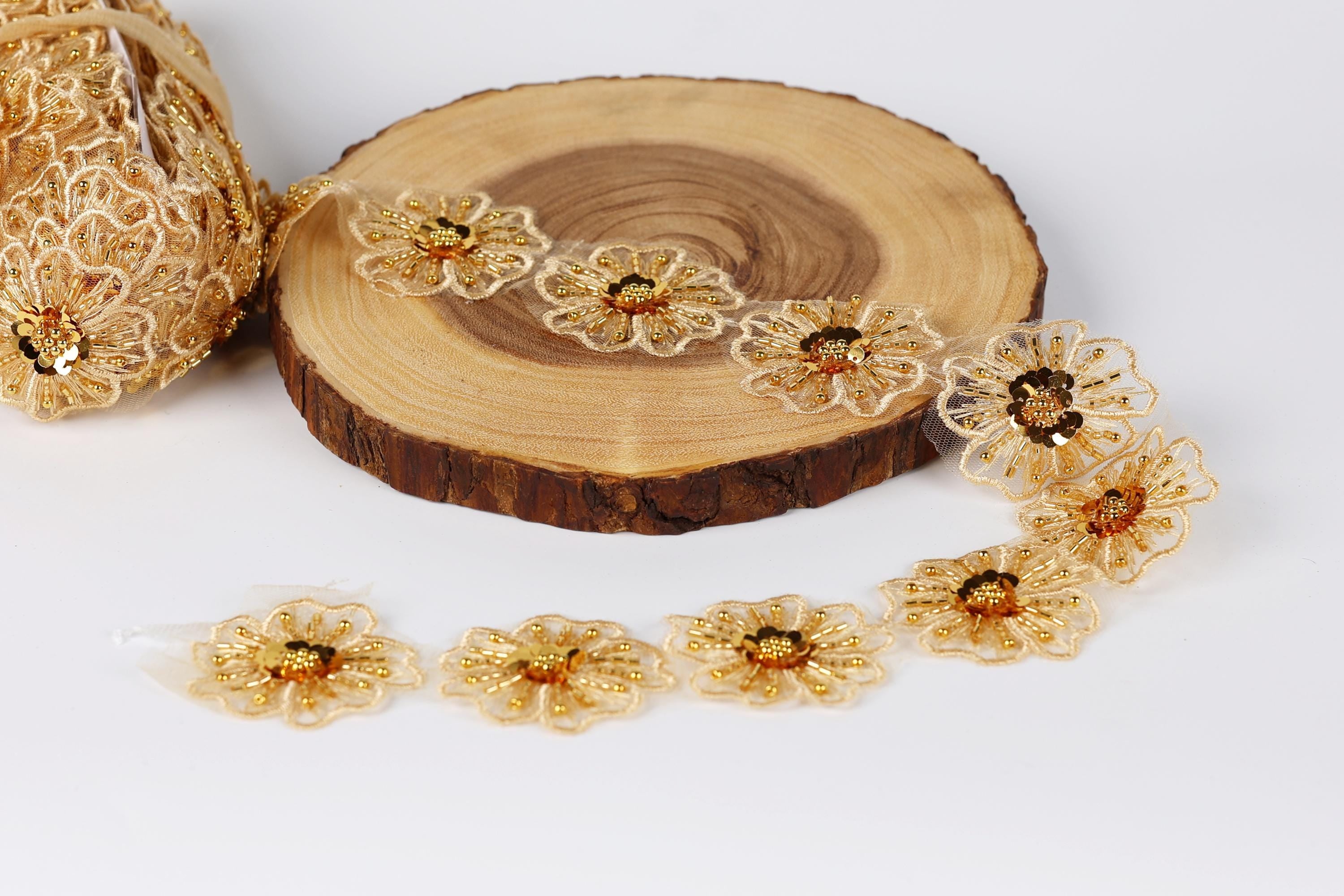 a collection of gold-colored, intricately designed flowers arranged on a wooden surface.