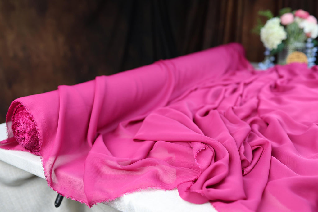 a close up of a pink sheet on a bed