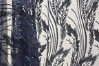 a close-up view of a fabric with a black and white floral pattern, with a dark blue sequin overlay.