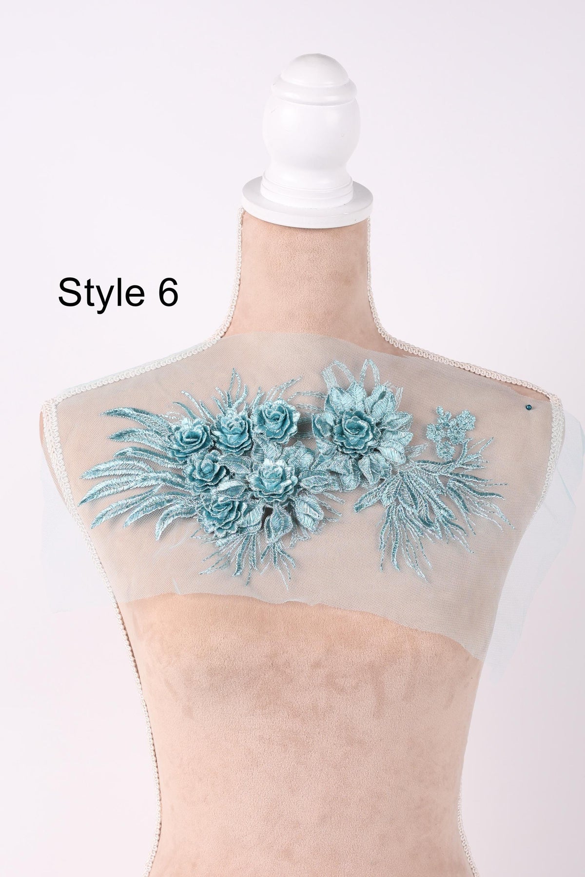 A mannequin with a floral embroidered piece of fabric on its back.