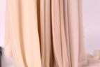 A close-up view of a fabric with a soft, light beige color.