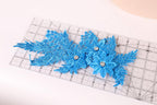 a clear ruler with blue glittery flower-like decorations placed on it.