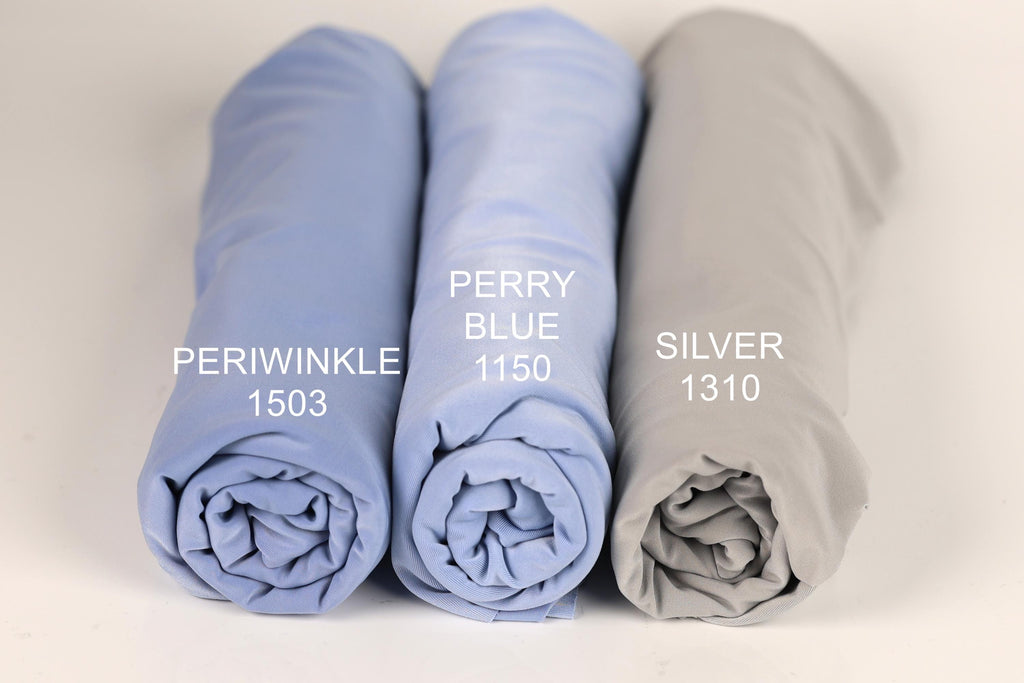 three rolled-up fabric swatches in different colors: blue, purple, and gray. Each swatch has a label indicating the color and a number, likely representing the swatch number or a reference for the color.