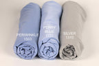 three rolled-up fabric swatches in different colors: blue, purple, and gray. Each swatch has a label indicating the color and a number, likely representing the swatch number or a reference for the color.