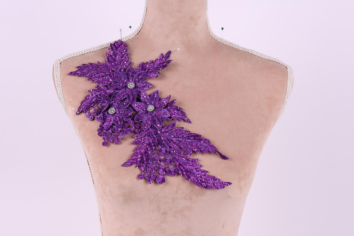 a mannequin with a purple glitter leaf design on its shoulder.