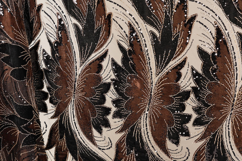 a close-up view of a fabric with a floral pattern in shades of brown and black, adorned with small white beads.