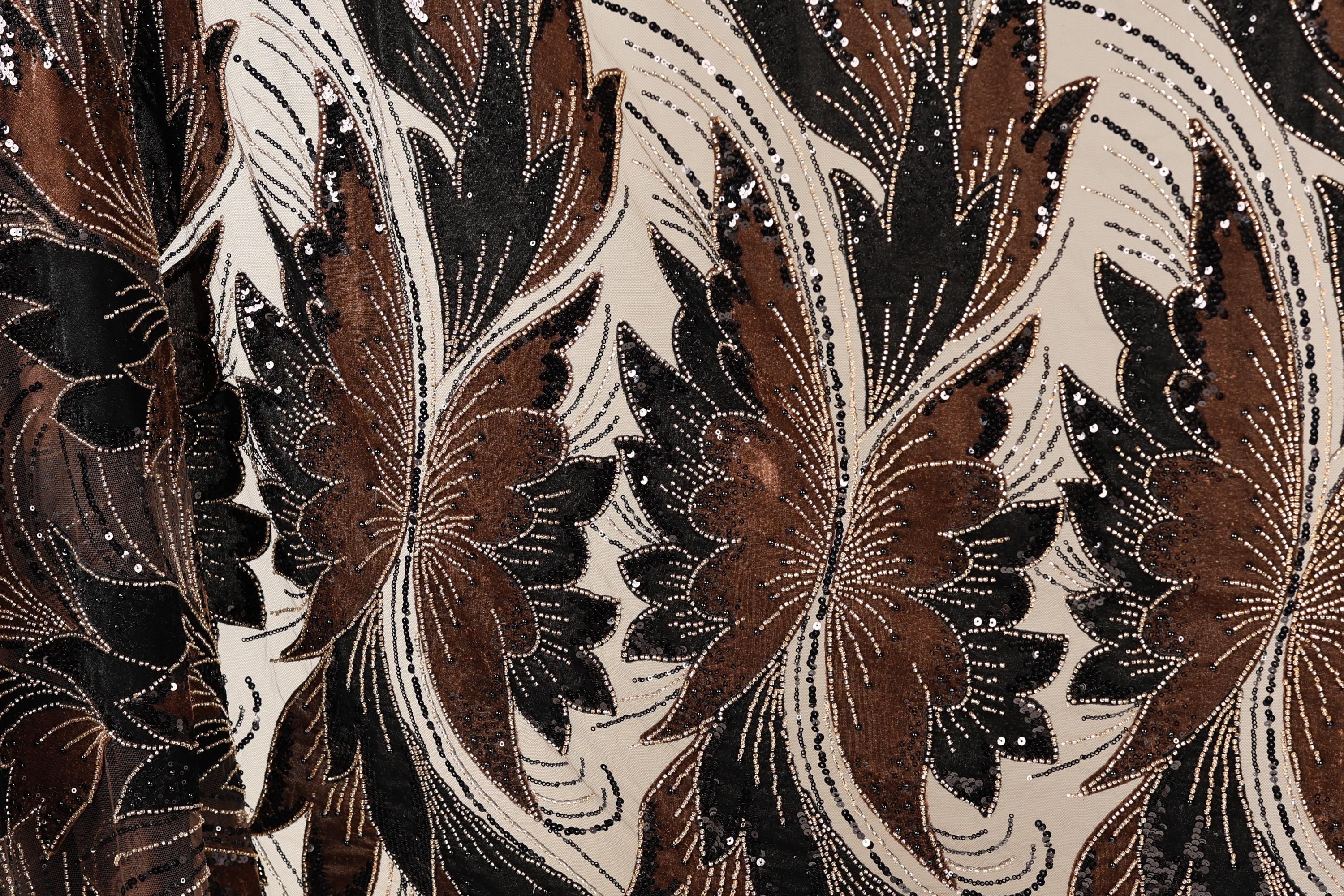 a close-up view of a fabric with a floral pattern in shades of brown and black, adorned with small white beads.