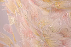 The image is a close-up of a fabric with a floral pattern, featuring a mix of pink, yellow, and white colors. The fabric appears to be made of a shiny, glittery material, adding a sparkly effect to the overall appearance.