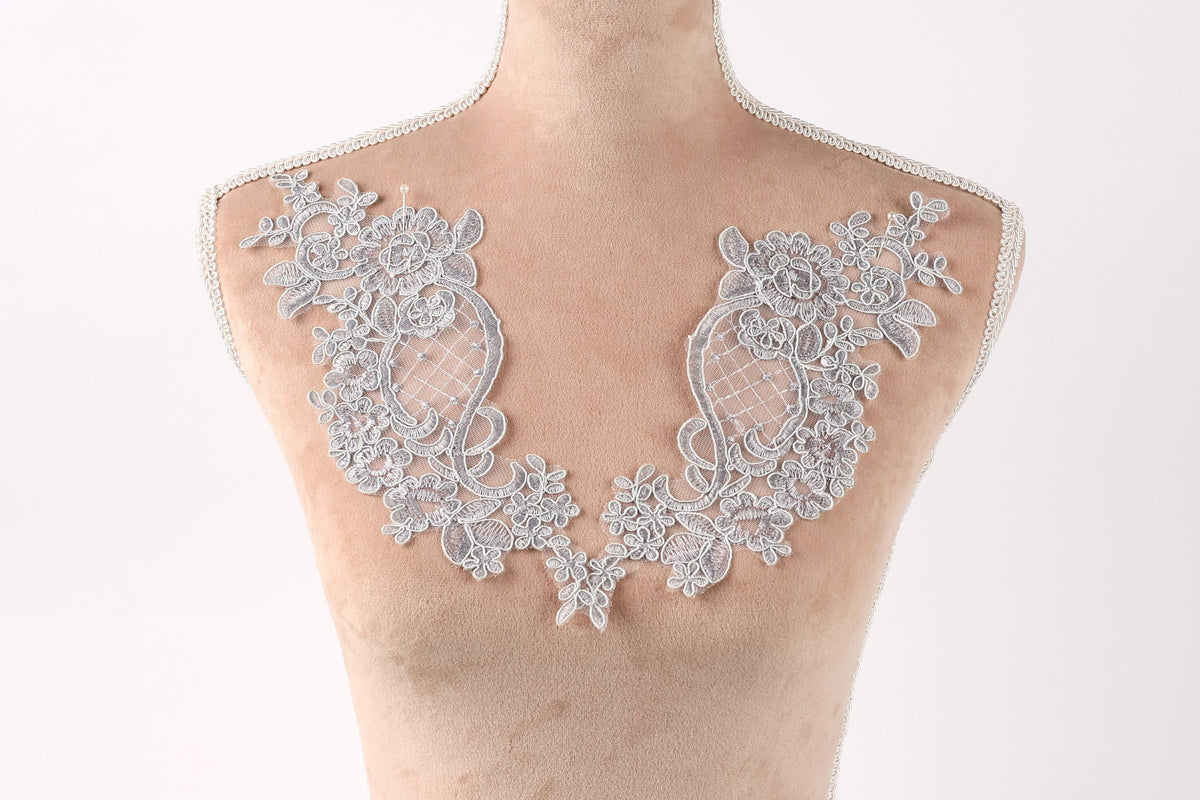 A mannequin with a decorative lace collar on its bust.