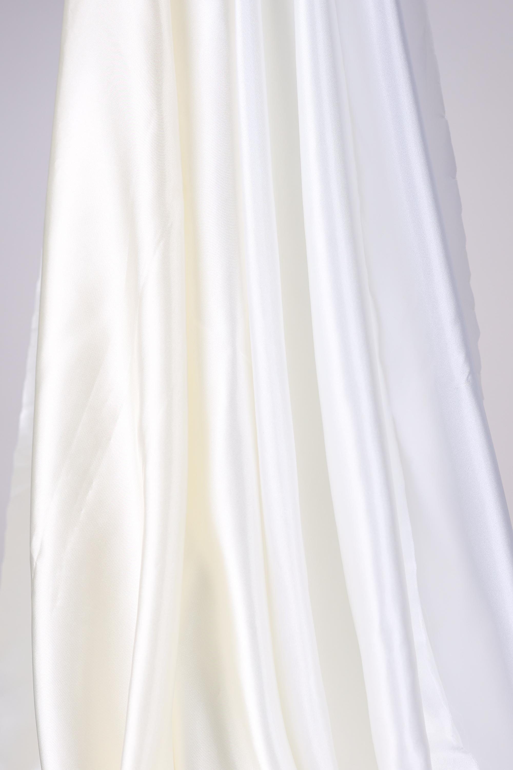 The image is a close-up of a white fabric, possibly silk or chiffon, with a soft, flowing texture.