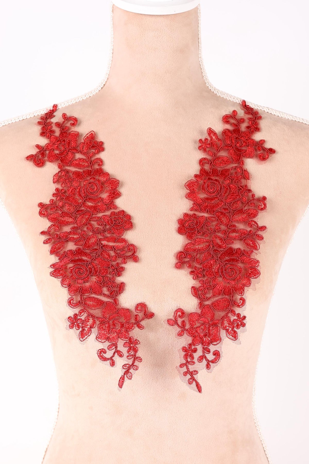 a close-up view of a person's body, with red floral embroidery or lace adorning the skin.